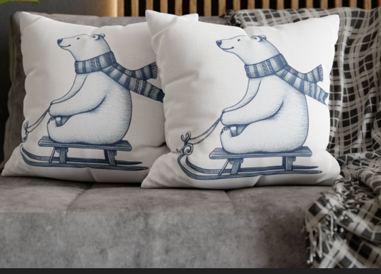 Two pillows with polar bear illustrations on a gray couch.