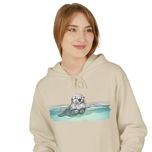 Person wearing a beige hoodie with a graphic of a sea otter and water design on a white background