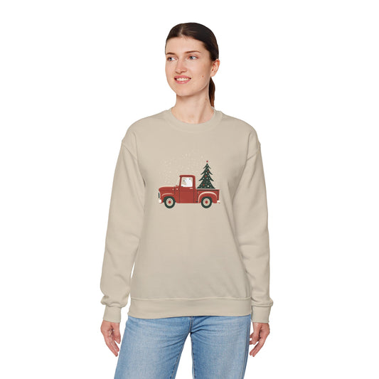 Woman wearing a beige sweatshirt with a red truck and Christmas tree design on a white background
