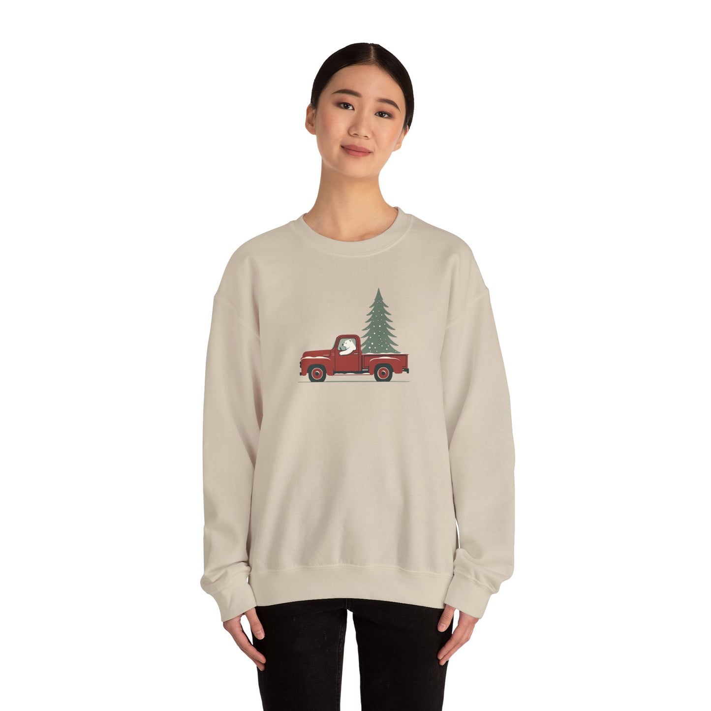 Person wearing a beige sweatshirt with a red truck and tree design on a white background