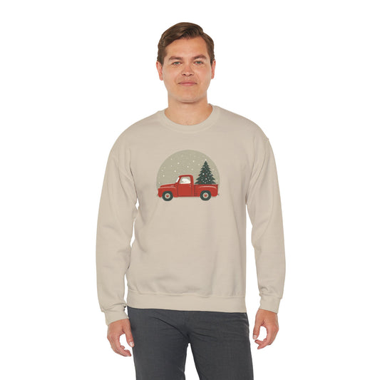 Man wearing a beige sweatshirt with a red truck and Christmas tree design on a white background