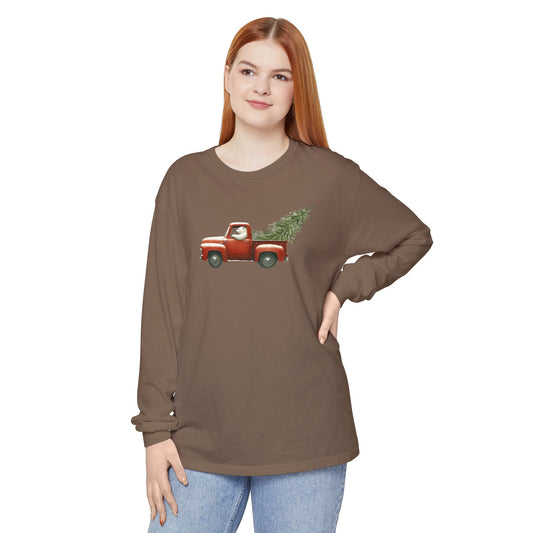 Woman wearing a brown long-sleeve shirt with a red truck and Christmas tree design on a white background