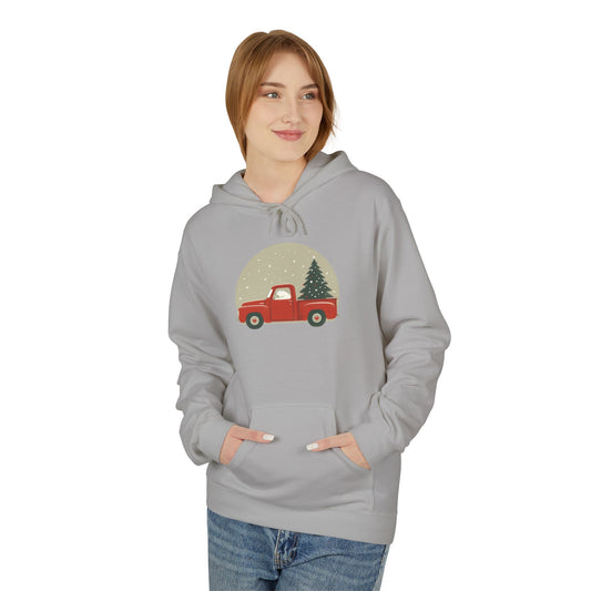 Person wearing a gray hoodie with a red truck and Christmas tree design on a white background