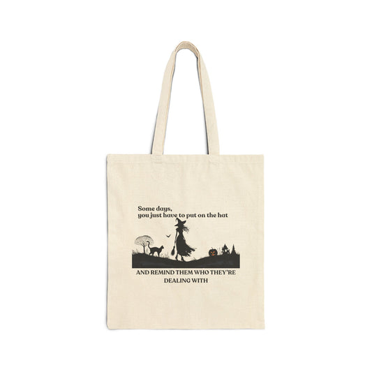 Beige tote bag with black witch and cat  silhouette design and text on a white background