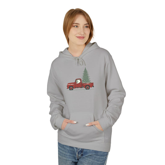 Person wearing a gray hoodie with a red truck and Christmas tree design on a white background