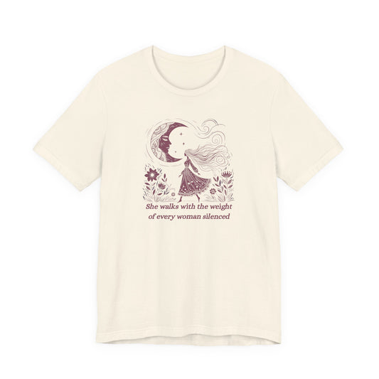 Empowering feminist t-shirt with illustrated woman walking under the moon, floral design, and the quote "She walks with the weight of every woman silenced.