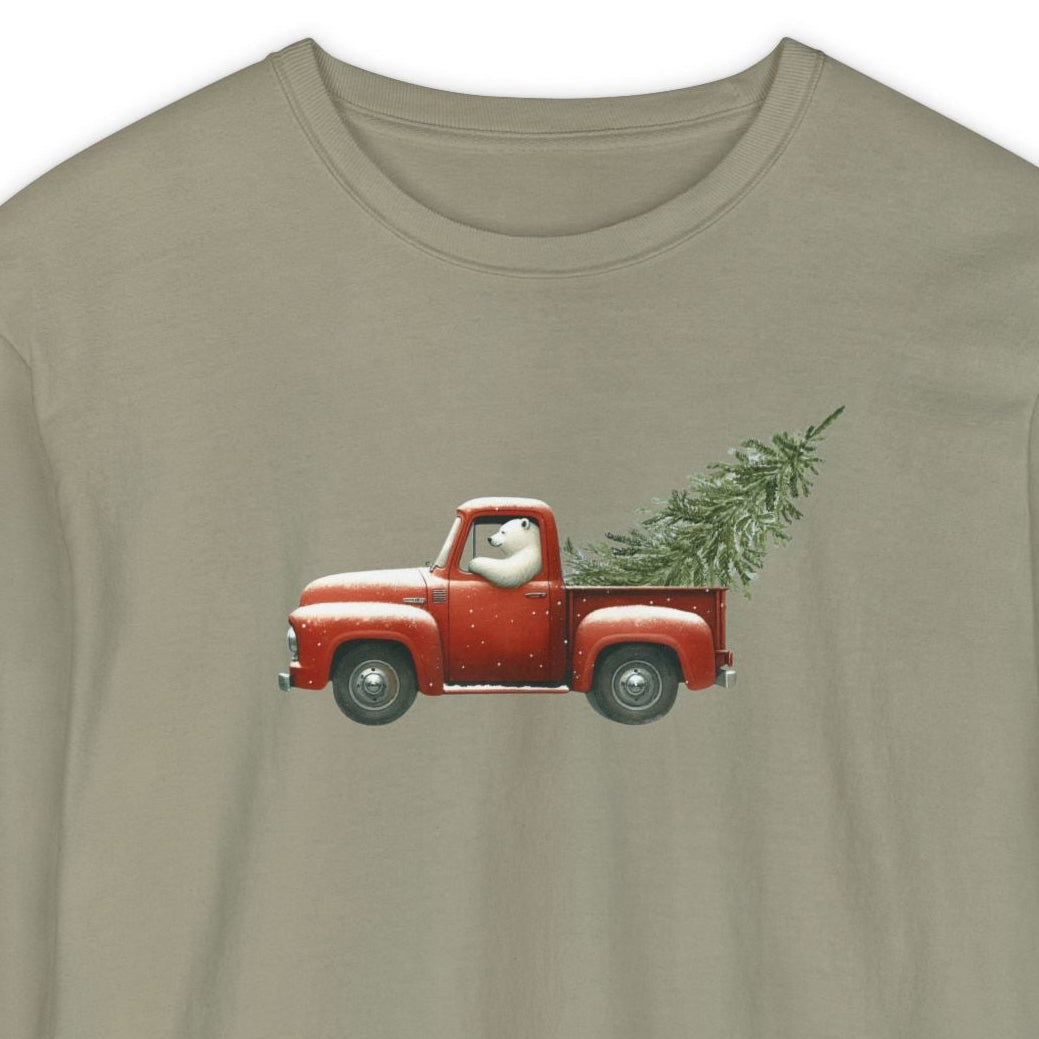 Beige long-sleeve shirt with a graphic of polar bear driving a red truck with a Christmas tree on a white background.