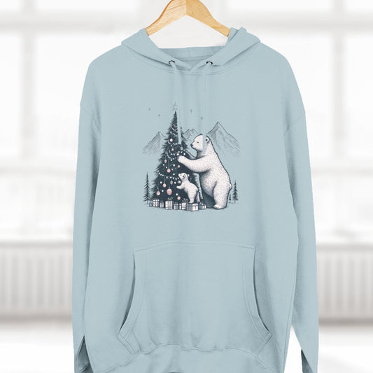 Light blue hoodie with a bear and tree design on a hanger against a white background