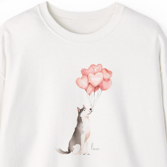 White sweatshirt with a graphic of a Siberian Husky holding a pink balloons on a white background