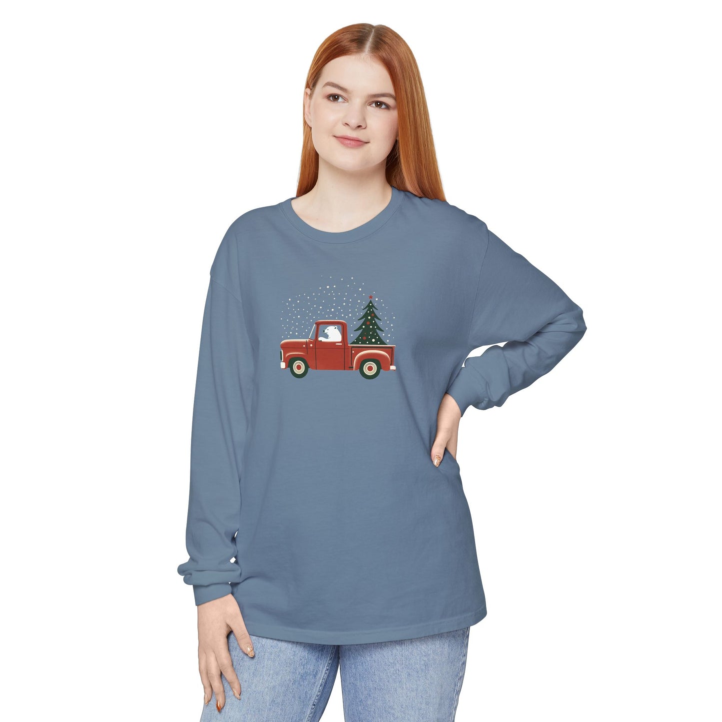 Woman wearing a blue long-sleeve shirt with a red truck and Christmas tree design on a white background